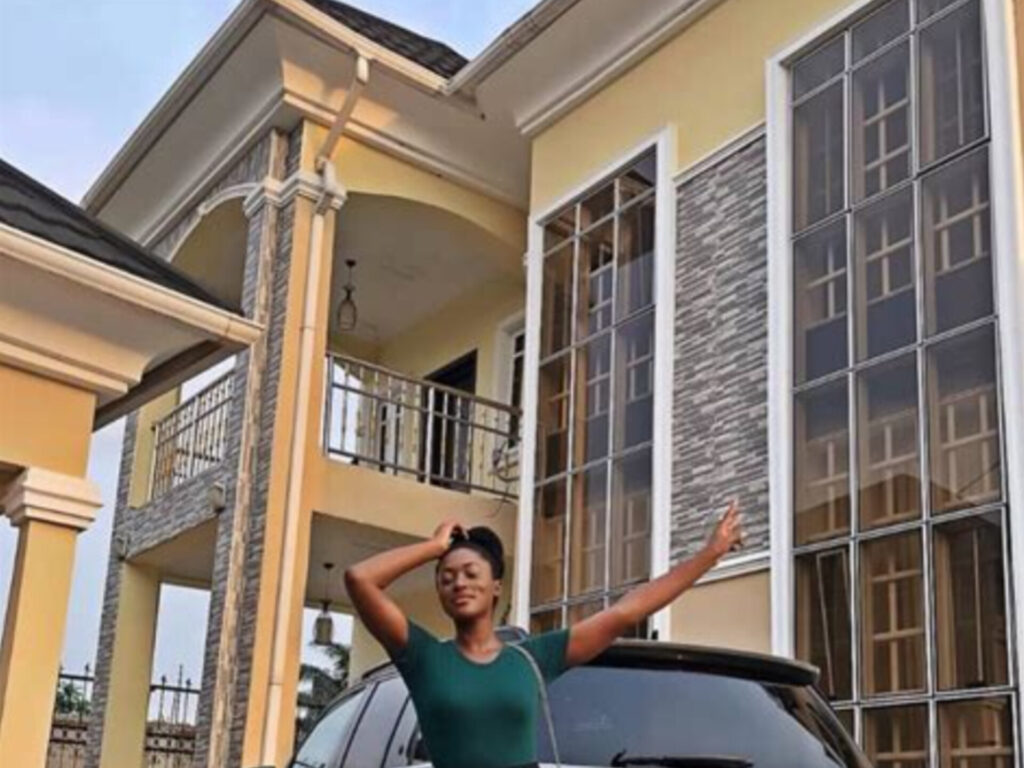 Linda posing in front of her new house.